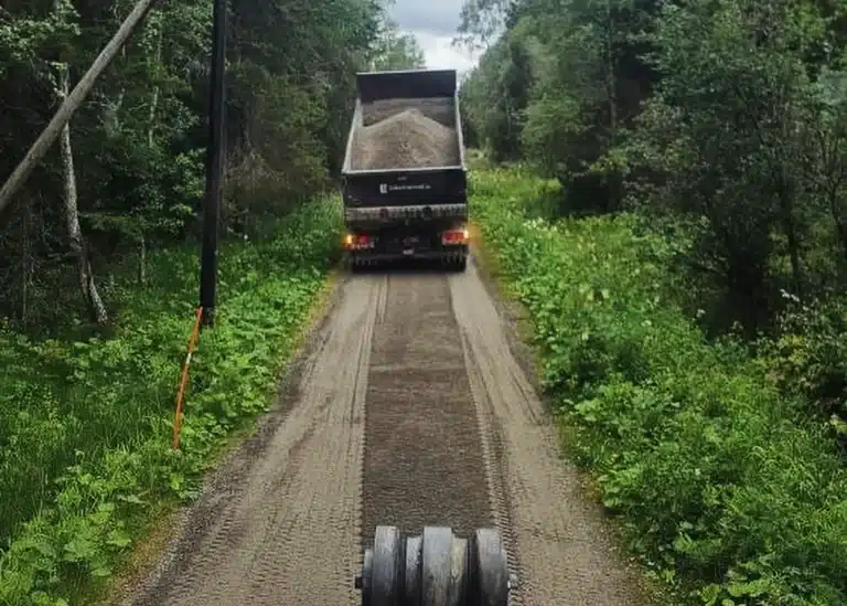 Spridning av väg med lastbil och hjullastare